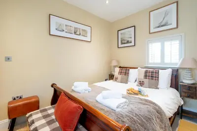 a bedroom with a bed with towels on it at Pebble Cottage - 6 Victoria Rd - Aldeburgh Coastal Cottages in Aldeburgh