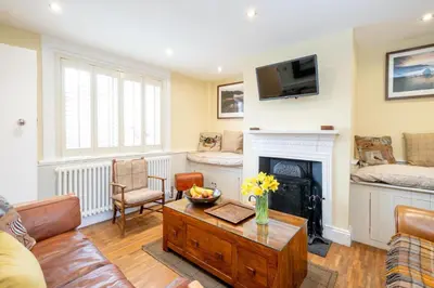 a living room with a couch and a fireplace at Pebble Cottage - 6 Victoria Rd - Aldeburgh Coastal Cottages in Aldeburgh