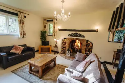 a living room with a fireplace and a couch and a table at Elizabethan Manor House - Sleeps 2-4 - Parking in Burnham on Crouch