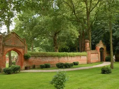a brick wall with an arch in a garden at Elizabethan Manor House - Sleeps 2-4 - Parking in Burnham on Crouch