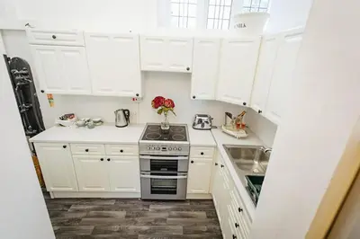 a white kitchen with a stove and a sink at Elizabethan Manor House - Sleeps 2-4 - Parking in Burnham on Crouch