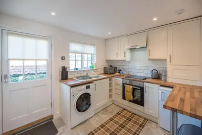 a kitchen with a washing machine and a washer at Candy Cottage, Halesworth in Halesworth