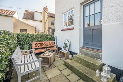 a patio with a bench and a table at Candy Cottage, Halesworth in Halesworth
