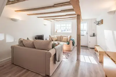 a living room with two couches and a table at Candy Cottage, Halesworth in Halesworth