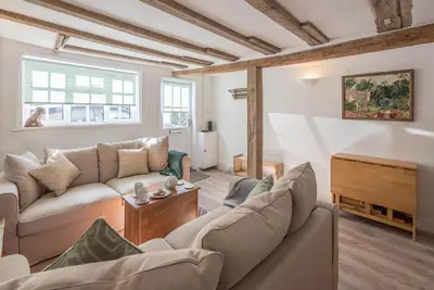 a living room with two couches and a tv at Candy Cottage, Halesworth in Halesworth