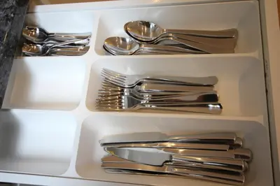 a white drawer filled with silver utensils at Cambridge city centre immaculate 2 bed apartment in Cambridge
