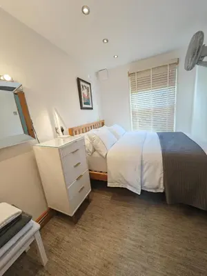 a bedroom with a bed and a dresser and a window at Cambridge city centre immaculate 2 bed apartment in Cambridge
