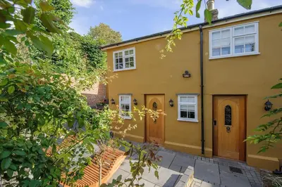 a large yellow house with a wooden door at Huge Deluxe 600 Year Old Essex Manor, Hot Tub, Cinema Room, Sky Tv in Saffron Walden