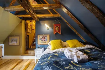 a bedroom with a large bed in a attic at Huge Deluxe 600 Year Old Essex Manor, Hot Tub, Cinema Room, Sky Tv in Saffron Walden