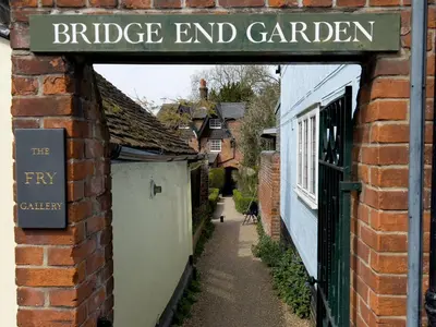 a sign for a bridge end garden on a brick building at Miller Cottage a luxury 1550's cottage in the Historic centre of Saffron Walden in Saffron Walden