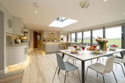 a kitchen and dining room with a table and chairs at White Cottage, Iken - Aldeburgh Coastal Cottages in Snape