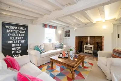 a living room with white furniture and a fireplace at White Cottage, Iken - Aldeburgh Coastal Cottages in Snape
