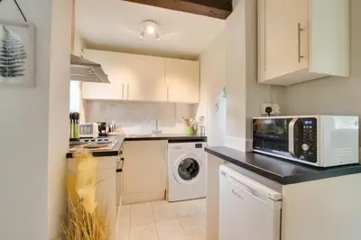 a kitchen with a microwave and a washer and dryer at 3 Bed in Letheringham oc-pclet in Kettleburgh