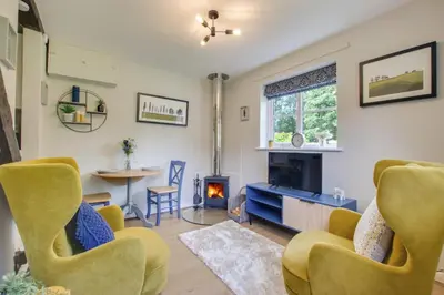 a living room with yellow chairs and a fireplace at 3 Bed in Letheringham oc-pclet in Kettleburgh