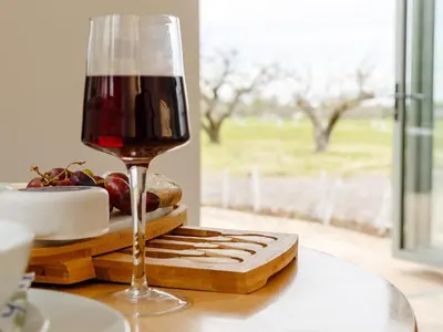 a glass of wine sitting on top of a table at Bramley Cottage in North Weald