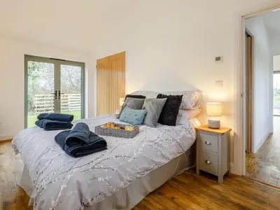 a bedroom with a bed with towels on it at Bramley Cottage in North Weald