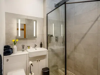 a bathroom with a sink and a shower at Bramley Cottage in North Weald