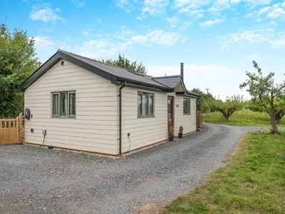 a small white house with a gravel driveway at Bramley Cottage in North Weald