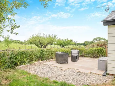 a patio with two trash cans next to a fence at Bramley Cottage in North Weald