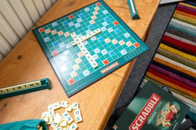 a monopoly game on a table with a book at Mere Cottage - Aldeburgh Coastal Cottages in Thorpeness