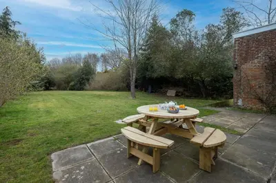 a picnic table and two benches in a yard at Mere Cottage - Aldeburgh Coastal Cottages in Thorpeness