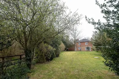 a large yard with a house and a tree at Mere Cottage - Aldeburgh Coastal Cottages in Thorpeness