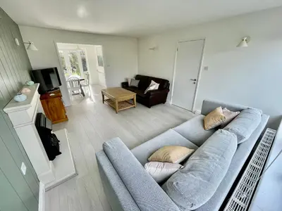 a living room with a blue couch and a chair at Island House in West Mersea