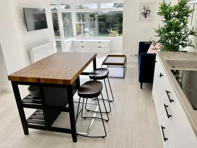 a kitchen with a table and stools in a room at Island House in West Mersea