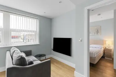 a living room with a couch and a tv and a bed at Luxury Apartment in Chelmsford Bond Street with Sky TV, Movies & Netflix in Chelmsford