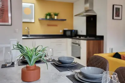 a kitchen with a table with plates and bowls on it at Two Bedroom Coach House - Free Allocated Parking for 2 vehicles - Central Colchester in Colchester