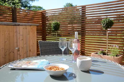 a table with two wine glasses and a bowl of food at May Barn, Ixworth in Ixworth