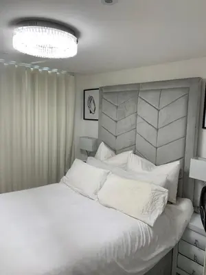 a white bedroom with a large bed with white pillows at A BYK luxury modern home that sleeps 2 - 8 people in Horndon on the Hill