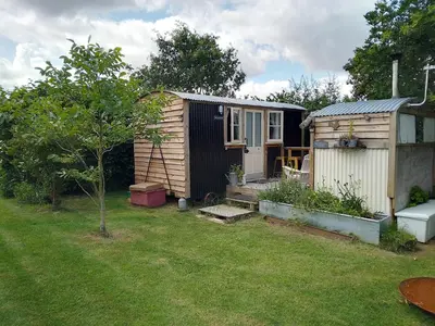 a small house and a shed in a yard at Mr Hares shepherd hut in Mellis