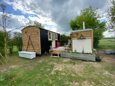 a tiny house and a bath tub in a yard at Mr Hares shepherd hut in Mellis