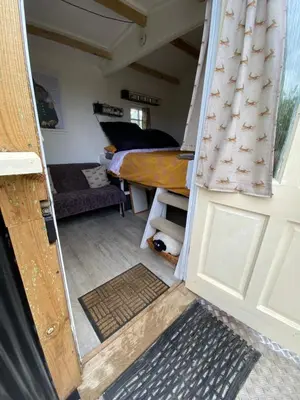 a view of a room with a bed and a door at Mr Hares shepherd hut in Mellis