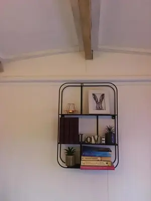 a shelf on the side of a wall with books at Mr Hares shepherd hut in Mellis