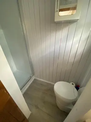 a small bathroom with a toilet and a window at Mr Hares shepherd hut in Mellis