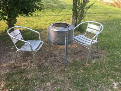 two chairs and a grill in a yard at Mr Hares shepherd hut in Mellis
