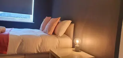a bedroom with a bed with pillows and a table at The Court in Braintree