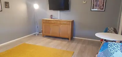 a living room with a table and a tv on a wall at The Court in Braintree