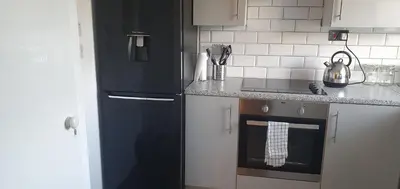 a kitchen with a black refrigerator and a stove at The Court in Braintree