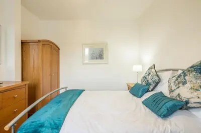 a bedroom with a white bed with blue pillows at Beautiful and Spacious Cambridge Home with Free Parking & Garden! in Cambridge