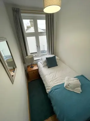 a bedroom with a twin bed and a window at Beautiful and Spacious Cambridge Home with Free Parking & Garden! in Cambridge