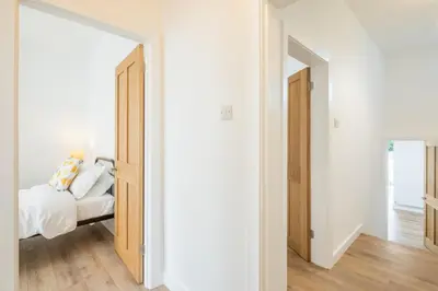 a bedroom with a bed and an open doorway at Cosy Two Bedroom Apartment in Excellent Location in Chesterton