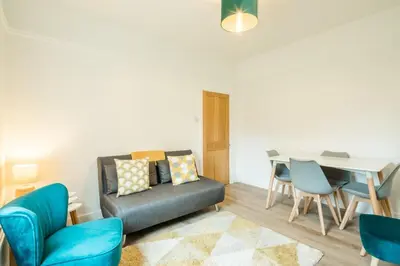a living room with a couch and a table and chairs at Cosy Two Bedroom Apartment in Excellent Location in Chesterton