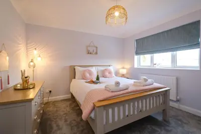 a bedroom with a bed with two towels on it at 2 Hillcrest - Aldeburgh Coastal Cottages in Leiston