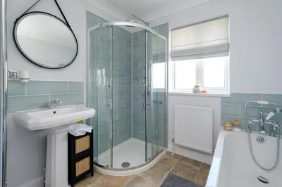 a bathroom with a shower and a sink and a tub at 2 Hillcrest - Aldeburgh Coastal Cottages in Leiston