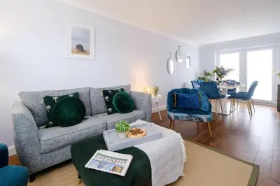 a living room with a couch and a table at 2 Hillcrest - Aldeburgh Coastal Cottages in Leiston
