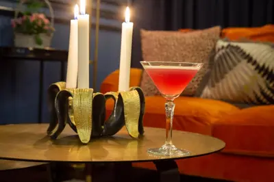 a drink on a table next to two candles at Worlington Hall in Worlington