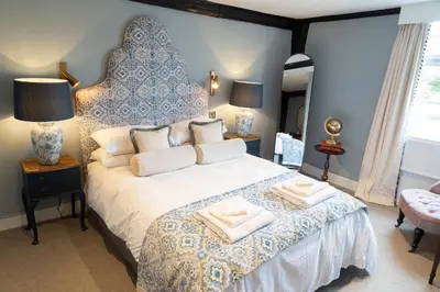 a bedroom with a large bed with towels on it at Worlington Hall in Worlington